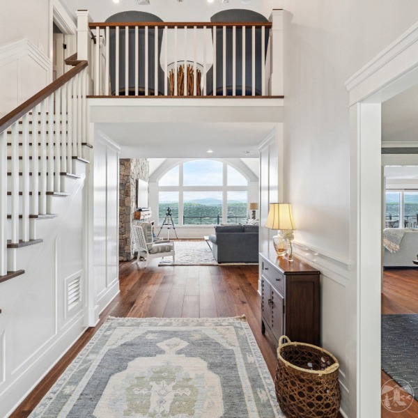 Floor-to-ceiling custom windows framing lake and mountain views at luxury Lake Winnipesaukee remodel